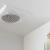 Ventilatore da soffitto bianco con pale elicoidali, discreto e funzionale per un ambiente fresco.