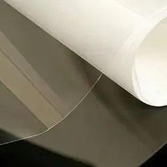 Foglio di materiale riflettente luce, trasparente e bianco, con pieghe morbide.