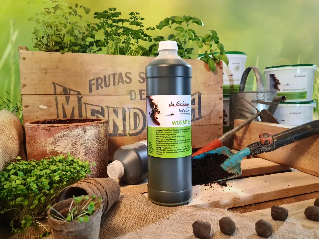 Flacone di humus di lombrico, terriccio, piantine e attrezzi da giardinaggio.